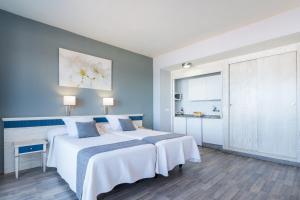 a hotel room with a bed and a dresser at Apartamentos Colón Playa in Las Palmas de Gran Canaria