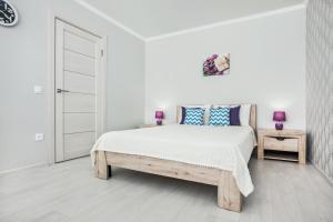 トリヤッチにあるSweet Marshmallow Apartment SUTKI LIFEの白いベッドルーム(紫色の枕を使用した大型ベッド1台付)