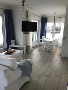 a living room with a couch and a table at Strandhaus Appartement - Seeschwalbe OG in Fehmarnsund