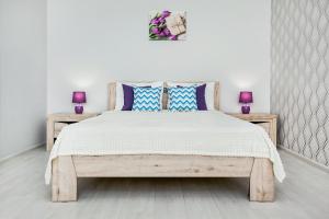 トリヤッチにあるSweet Marshmallow Apartment SUTKI LIFEのベッドルーム1室(木製ベッド1台、青い枕付)