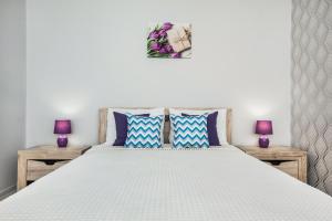 トリヤッチにあるSweet Marshmallow Apartment SUTKI LIFEのベッドルーム(紫色のランプ2つ付きの白いベッド1台付)
