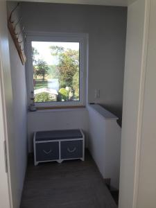 um pequeno quarto com uma janela e uma escada em Strandhaus-Appartment-Rauchschwalbe em Fehmarnsund