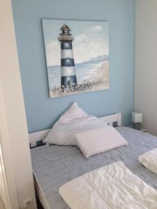 a bedroom with a bed and a picture of a lighthouse at Strandhaus-Appartment-Rauchschwalbe in Fehmarnsund