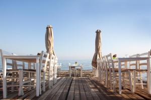 a table and chairs on a boardwalk on the beach at Golden Star City Resort in Perea