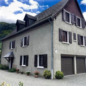 a house with black shuttered windows and plants at Venasque Vue Apartment in Saint-Mamet