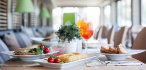 a table with plates of food and a glass of wine at Golden Star City Resort in Perea