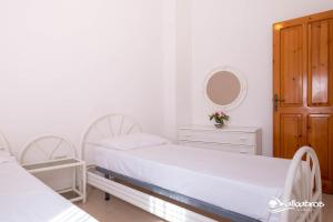 biała sypialnia z 2 łóżkami i lustrem w obiekcie Residence Albatros w mieście Briatico