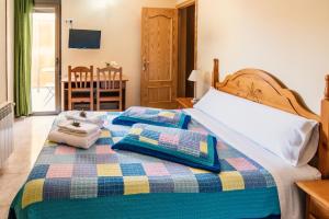 a bedroom with a bed with two pillows on it at Apartamentos Maribel in Calaceite