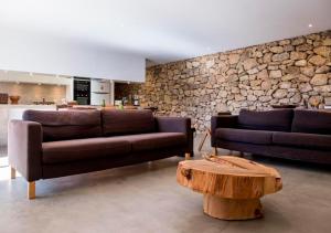 una sala de estar con 2 sofás y una pared de piedra. en ALENTEJO Mountain Vacation House, en Castelo de Vide