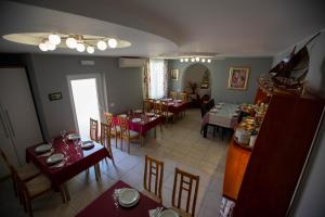 une salle à manger avec des tables et des chaises et une salle avec un archer dans l'établissement Pansion Boris, à Međugorje