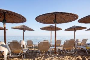 a group of chairs and umbrellas on a beach at Golden Star City Resort in Perea