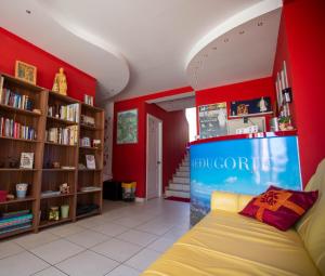 - un salon avec des murs rouges et un canapé dans l'établissement Pansion Boris, à Međugorje