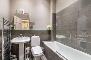 uma casa de banho com um lavatório, um WC e uma banheira em Richmond - 2 Bed court flat with allocated parking em Richmond