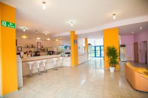 Un vestíbulo con columnas amarillas y un bar con taburetes. en Hotel Bohemi, en Sunny Beach