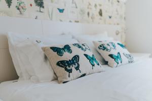 フンシャルにあるMansarda dos Aranhas by Madeira Best Apartmentsの白いベッド(青い蝶の枕付)