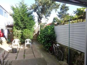 a garden with two white chairs and a bike at Portuense Alojamento Local in Porto