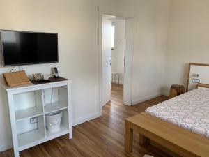 a bedroom with a bed and a flat screen tv at Die Weinsiedelei in Löhne