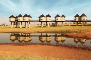 a row of houses reflected in a body of water at Salt Lick Safari Lodge in Tsavo