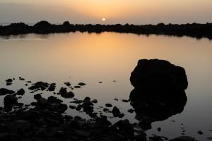 a sunset over a lake with rocks in the water at Home2Book Stunning View La Era de Hermigua & Wifi in Hermigua