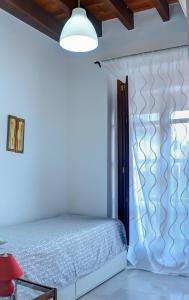 1 dormitorio con 1 cama en una habitación blanca en Balconies to the Orange Tree Square, en Sevilla