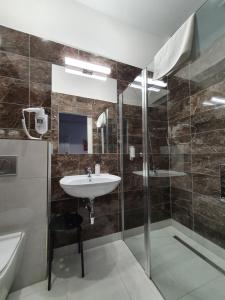 y baño con lavabo y ducha. en Pension Jana - Domov Mládeže, en Praga