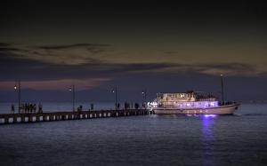 a boat on the water near a pier at night at Golden Star City Resort in Perea