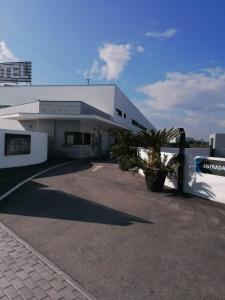 a building with a palm tree in front of it at Motel Eleven in Leiria