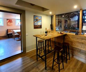 a bar with stools and a counter with wine glasses at De Nussi's chalet 2 in Bach