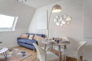a living room with a table and a blue couch at Stylish & Modern: Central Hitchin - with Parking in Hitchin