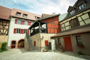 un grand bâtiment avec un escalier en face de celui-ci dans l'établissement Les chambres du domaine, à Eguisheim