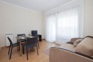sala de estar con mesa y sofá en Aparthotel Jardines de Aristi, en Vitoria-Gasteiz