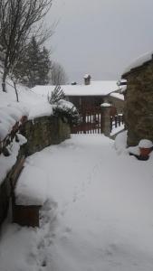 a yard covered in snow with a stone fence at B&B Borgo Valagnesi in Pratovecchio