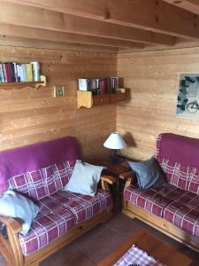 a room with two couches in a log cabin at Lyshytta in Saint-Pierre-dels-Forcats