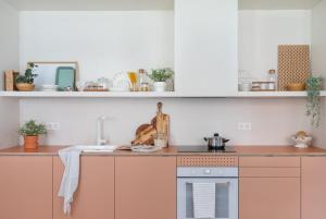 a kitchen with white cabinets and a stove top oven at Bilbao Park by Aston Rentals in Bilbao