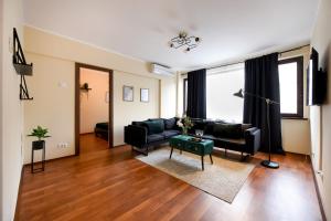 uma sala de estar com um sofá e uma mesa em THE CHIC & MODERN Apartment - Homey Bucharest em Bucareste