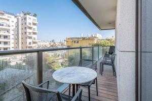 uma varanda com cadeiras, uma mesa e uma vista em Kerem Hateimanim Area-3 BR with Balcony em Tel Aviv