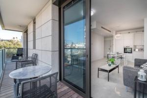 einen Balkon mit einem Tisch und ein Wohnzimmer in der Unterkunft Kerem Hateimanim Area-3 BR with Balcony in Tel Aviv