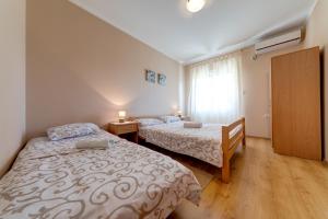a bedroom with two beds and a window at Apartments Pelle in Tivat