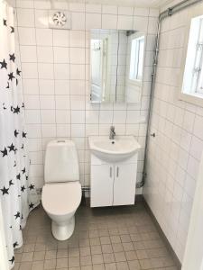 een witte badkamer met een toilet en een wastafel bij Falsterbo Camping Resort in Skanör med Falsterbo
