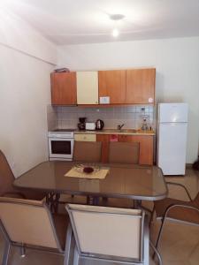 a small kitchen with a table and a refrigerator at Apartment by the beach - Nei Epivates in Neoi Epivates