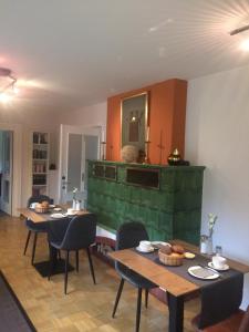 a living room with two tables and a green fireplace at Haus Luisenhof in Mölln