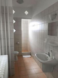 uma casa de banho com um lavatório e um WC em Tompos Vendégház és pince em Villány