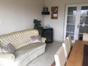 a living room with a couch and a table at Tompos Vendégház és pince in Villány