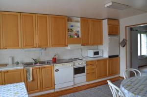una cucina con armadi in legno e un piano cottura bianco con forno di Sänkelä Cottage a Lämsä