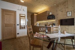 a dining room with a glass table and chairs at Baita Skianta in Bormio