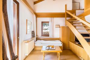 Habitación pequeña con cama y mesa de madera. en Hotel Cristiania en Madonna di Campiglio
