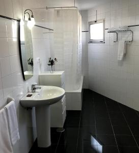 Baño blanco con lavabo y bañera en HOTEL DEL NORA en Noreña
