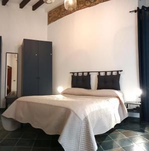 1 dormitorio con 1 cama con manta blanca y negra en Locazione breve in pieno centro "Blue House", en Palermo