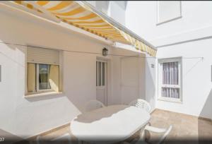 Biały pokój z białym stołem i krzesłami w obiekcie Apartamento Terraza soleada w mieście Conil de la Frontera