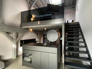 a loft kitchen with a staircase and a mirror at PÖLTER bei MARKUS T in Gütersloh